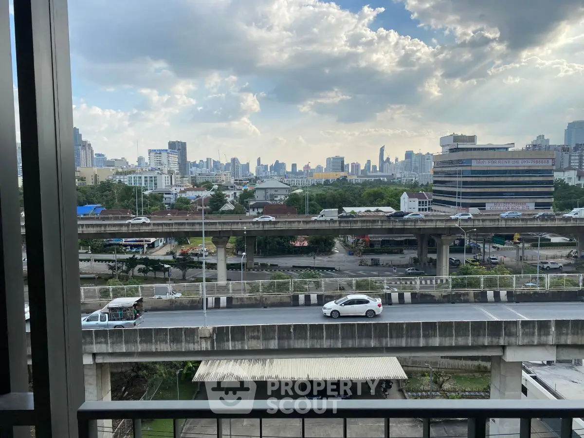 Stunning cityscape view from a high-rise balcony overlooking urban skyline and highways.