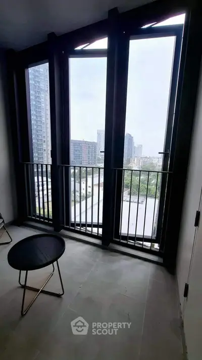 Modern apartment with floor-to-ceiling windows offering stunning city views, perfect for urban living.