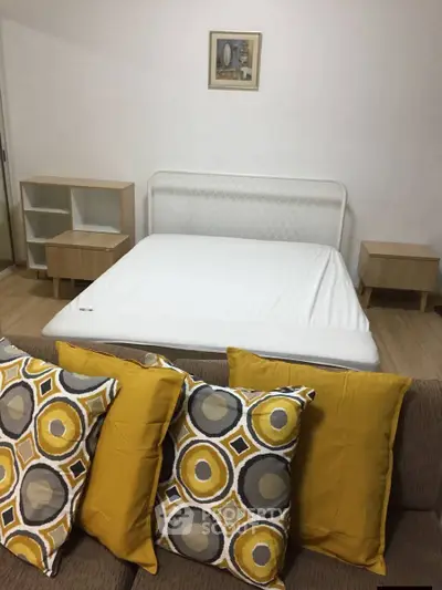 Cozy bedroom with modern decor and vibrant cushions, perfect for a relaxing retreat.