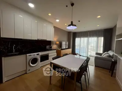 Modern open-layout kitchen and living room with city view, featuring sleek appliances and stylish decor.