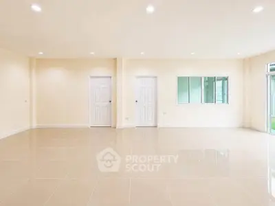 Spacious empty room with tiled flooring and ample natural light, perfect for customization.
