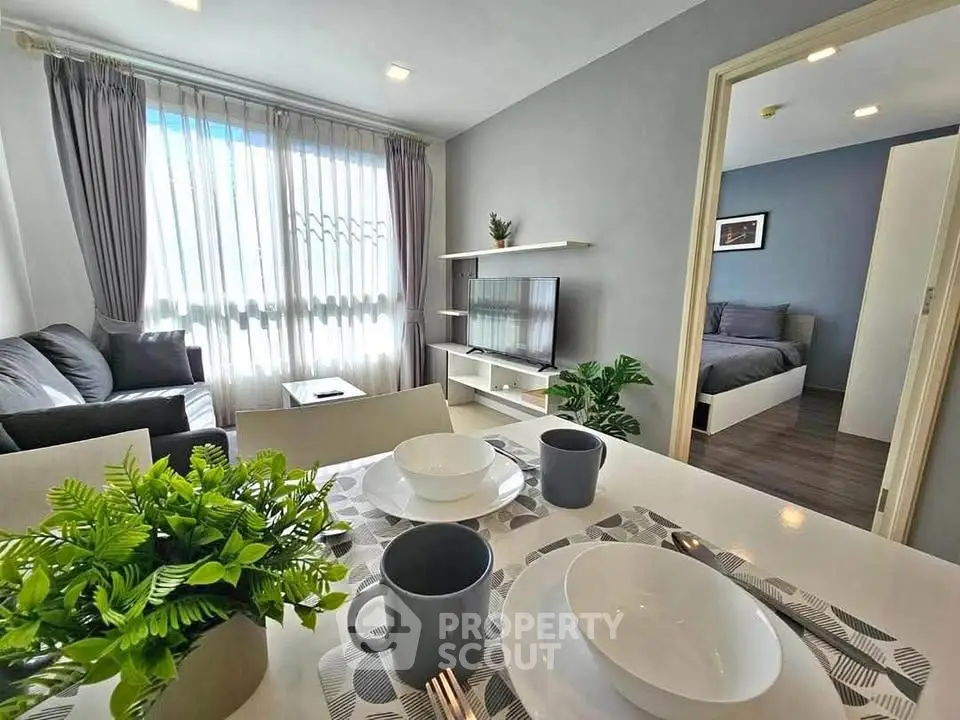 Modern living room with dining area and bedroom view, featuring stylish decor and natural light.