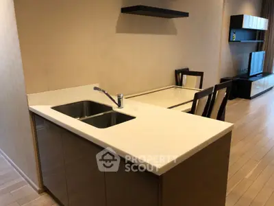 Modern open-layout kitchen with sleek countertops and integrated dining area in a stylish apartment.