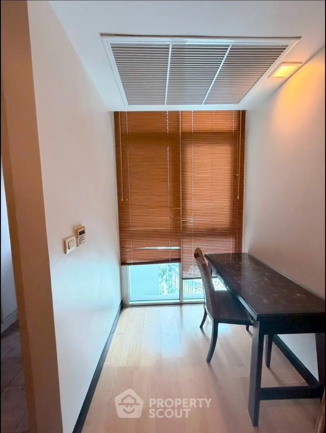Cozy study nook with natural light and wooden blinds, perfect for focused work or reading.