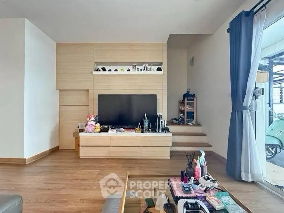 Modern living room with wooden flooring and built-in TV unit