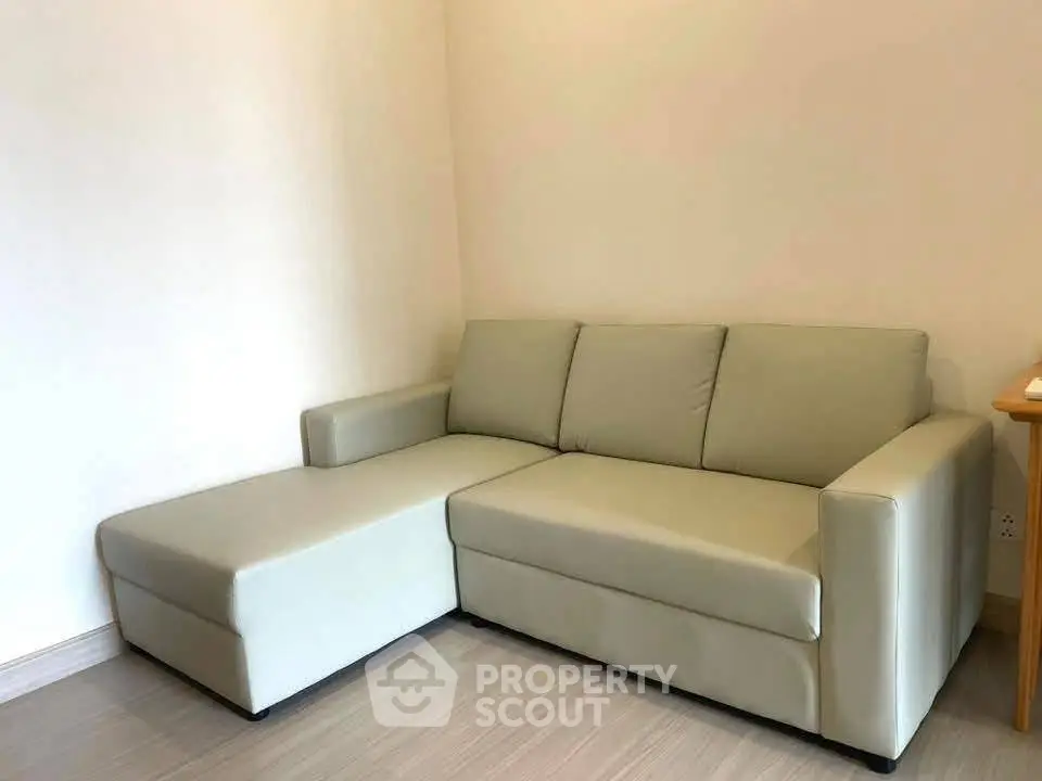 Modern living room with sleek beige sectional sofa and minimalist design.