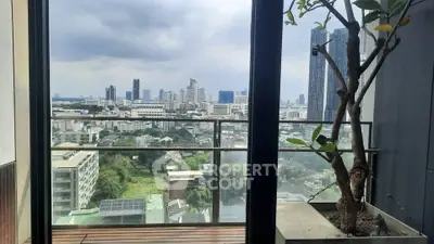 Stunning cityscape view from a modern balcony with glass railing and potted plant.