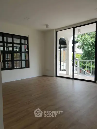 Spacious living room with large windows and balcony access