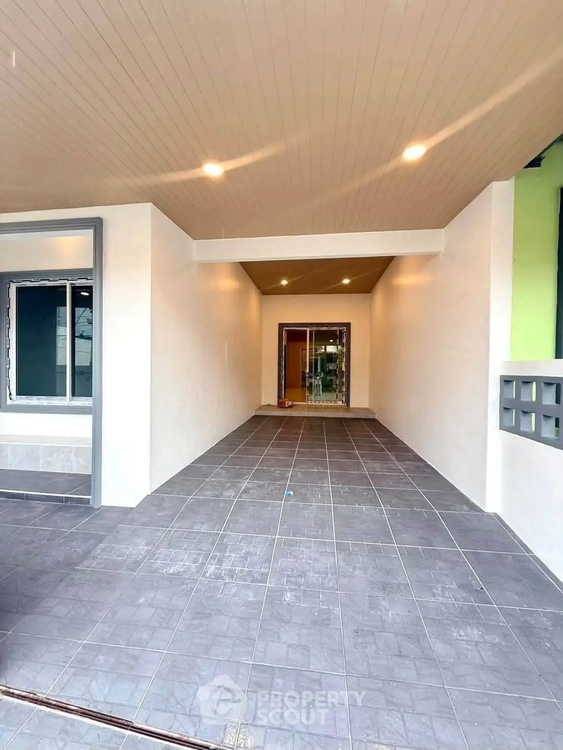 Spacious covered parking area with modern tiled flooring and recessed lighting.