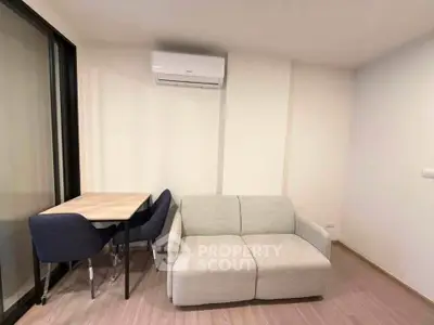 Modern living room with cozy sofa and dining table, featuring sleek air conditioning unit.