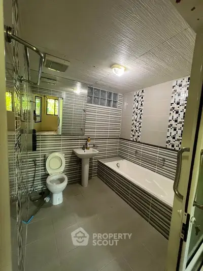 Spacious modern bathroom with bathtub and stylish tile design