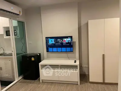 Modern living room with wall-mounted TV and sleek furniture in a stylish apartment.
