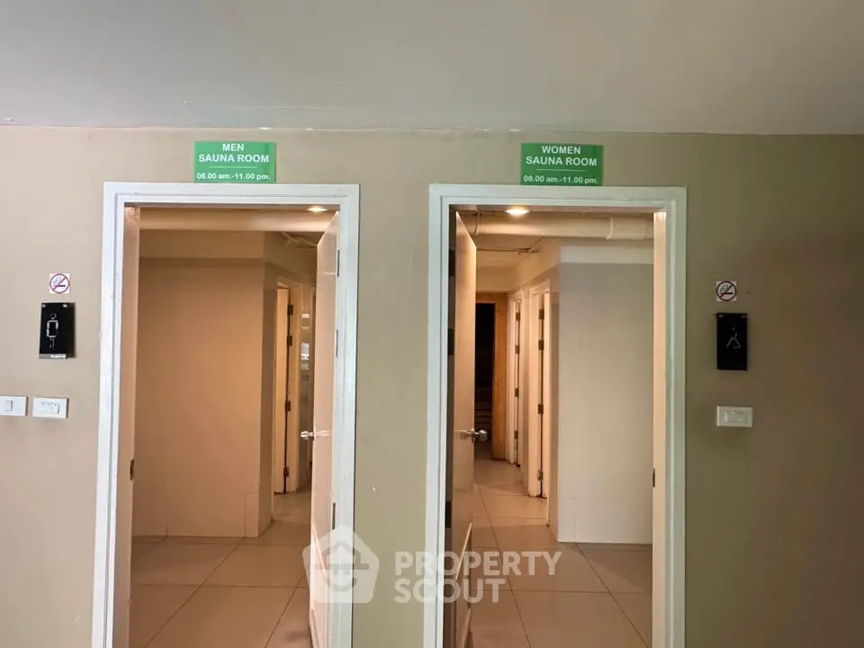 Modern sauna facility with separate entrances for men and women, featuring sleek design and clear signage.