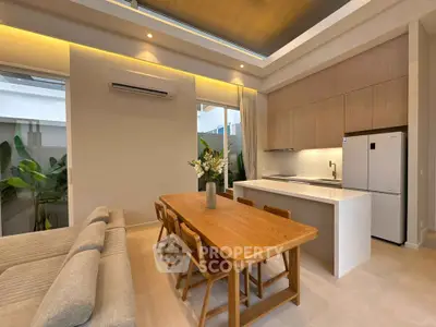 Modern open-layout kitchen and dining area with sleek design and natural lighting.