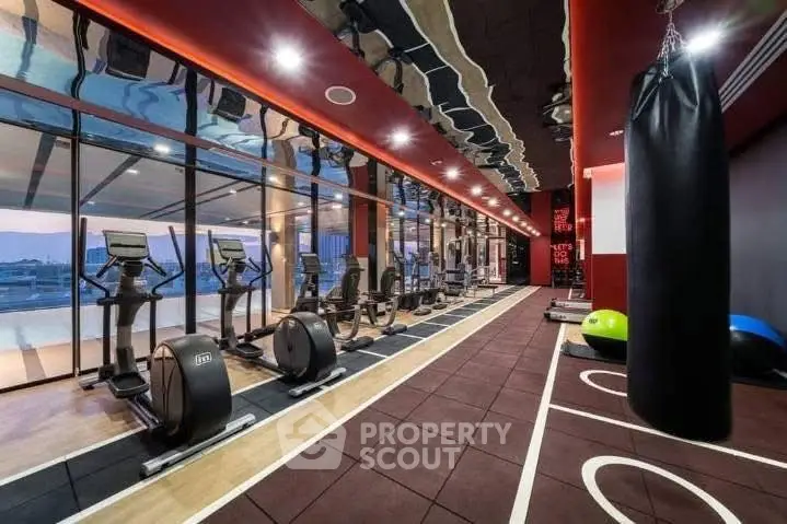 Luxury gym with modern equipment and panoramic city views in upscale residential building.