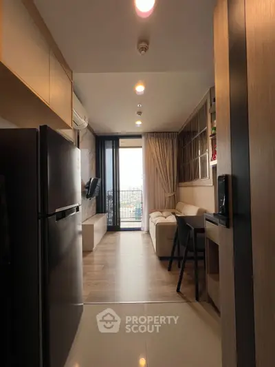 Modern living room with balcony view, sleek furniture, and open layout.