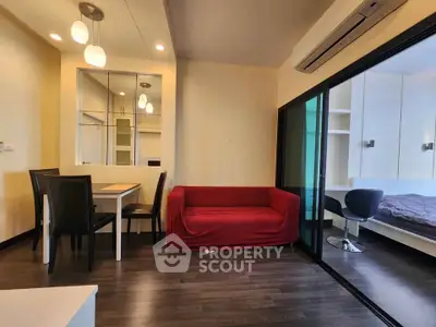 Modern apartment interior with cozy living room and adjacent bedroom, featuring stylish furniture and sleek design.