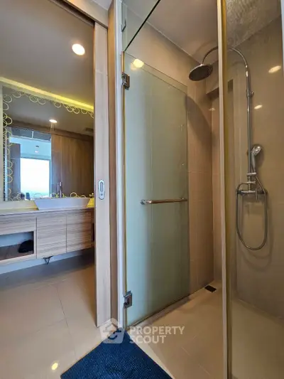 Modern bathroom with glass shower and wooden vanity in luxury apartment