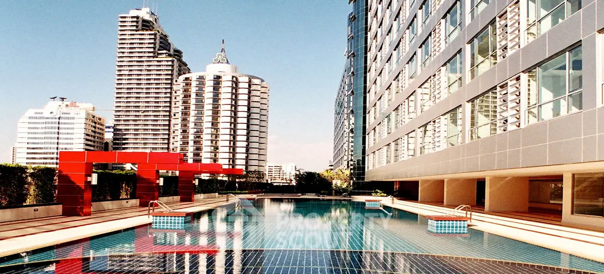 Luxurious urban poolside with modern architecture and stunning cityscape views.