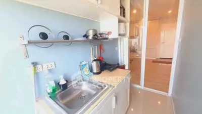 Modern kitchen with sleek design, featuring stainless steel sink and ample storage in a compact layout.