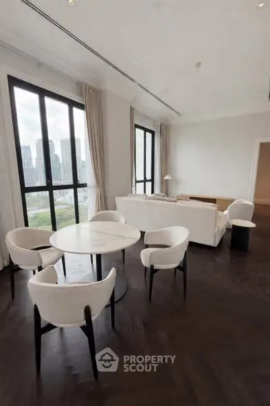 Luxurious living room with city view, elegant furniture, and large windows in a high-rise apartment.