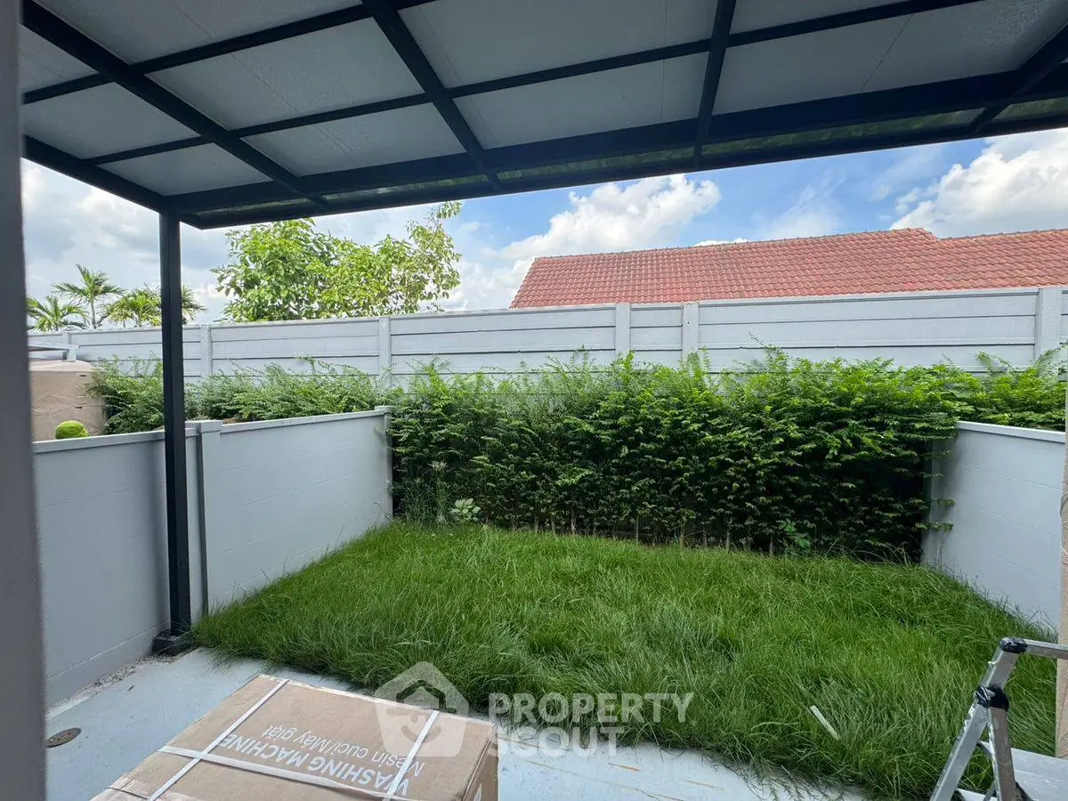 Charming backyard with lush greenery and modern pergola, perfect for outdoor relaxation.