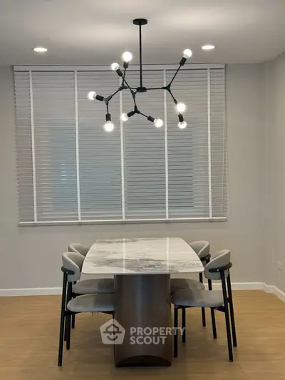 Modern dining area with elegant marble table and stylish lighting fixture