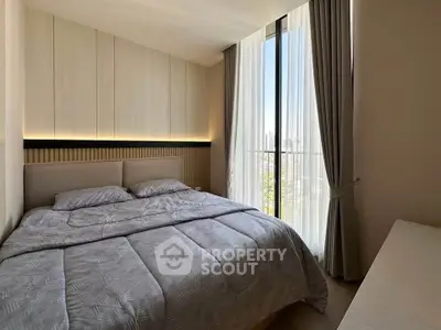 Cozy bedroom with large window and elegant curtains in modern apartment