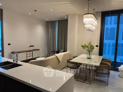 Modern open-plan living room with elegant dining area and stylish lighting in luxury apartment.