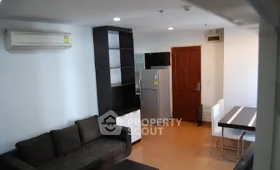 Modern living room with sleek furniture and open dining area, featuring air conditioning and stylish decor.