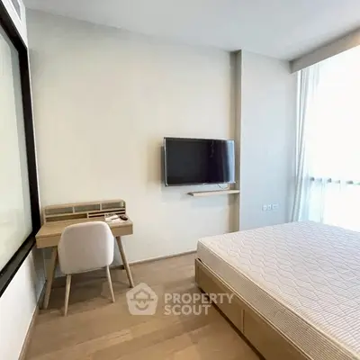 Modern minimalist bedroom with wall-mounted TV and sleek wooden furniture.