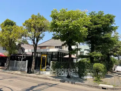 Charming corner unit house with lush greenery and modern design in a serene neighborhood.