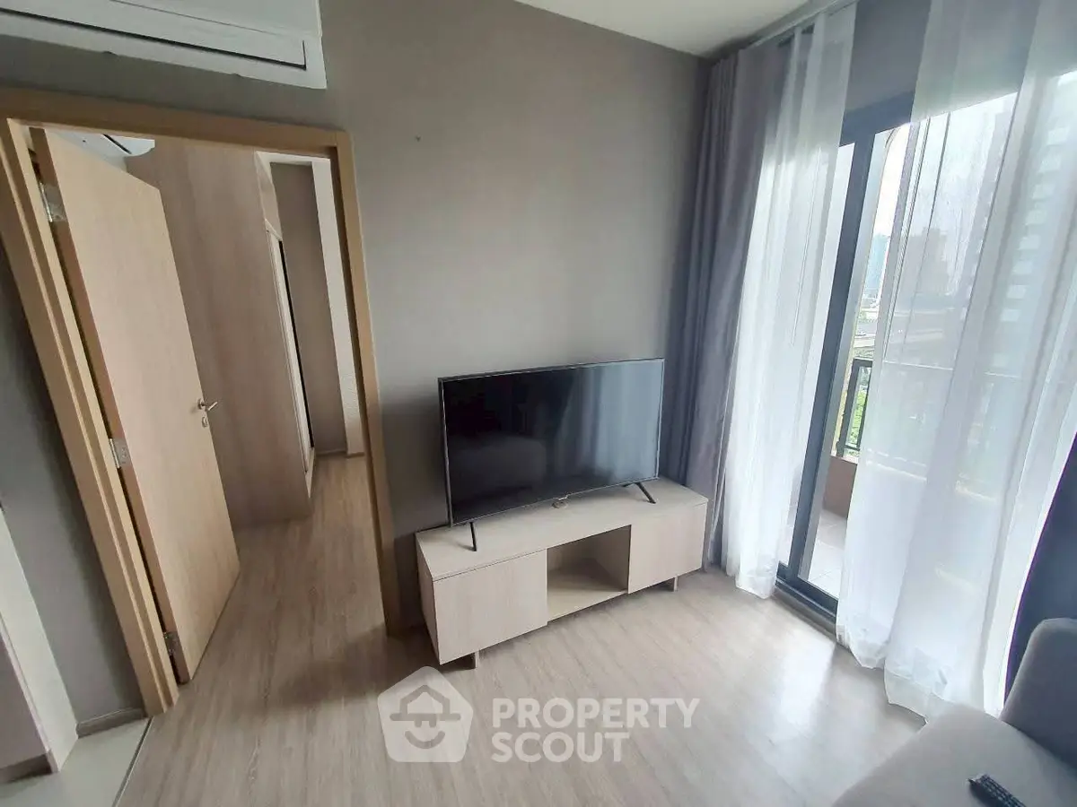 Modern living room with TV and balcony view in stylish apartment