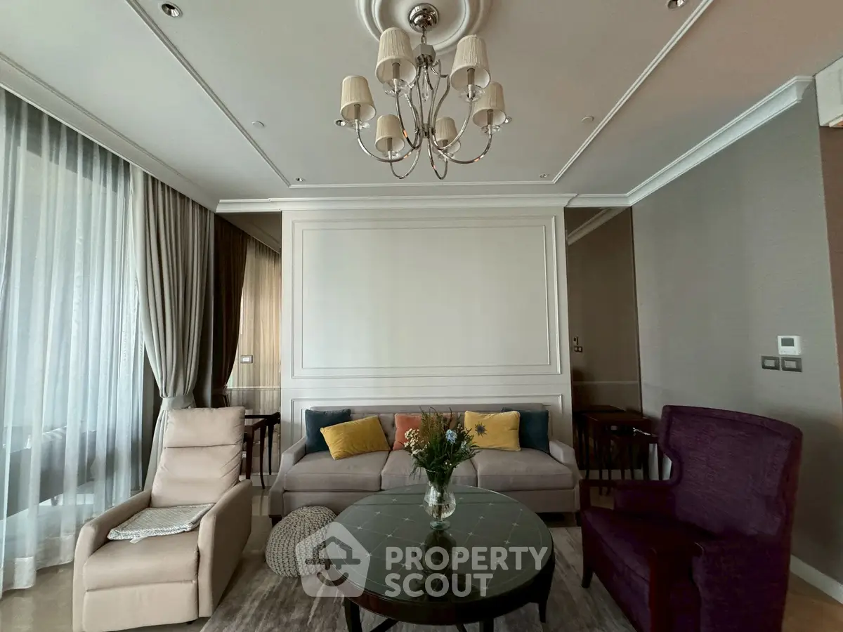 Elegant living room with plush seating, stylish chandelier, and large windows for natural light.