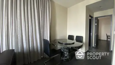 Modern dining area with elegant marble table and sleek black chairs in a stylish apartment.