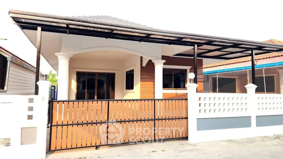 Charming single-story house with modern facade and gated entrance.