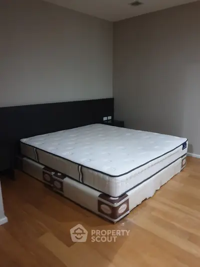 Spacious bedroom with a large comfortable mattress on wooden flooring