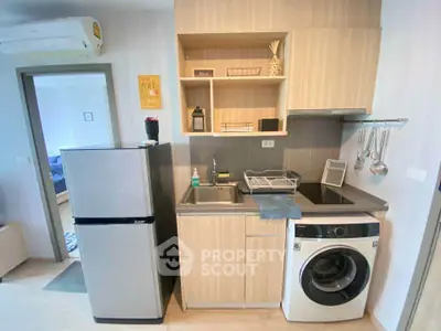 Modern compact kitchen with washing machine and fridge in cozy apartment