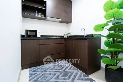 Modern kitchen with dark wood cabinets and sleek black countertops