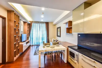 Modern open-layout living room with kitchen, featuring sleek cabinetry and stylish decor.