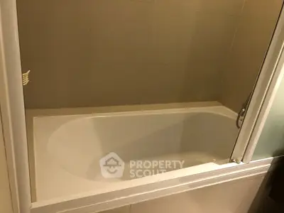 Modern bathroom with sleek bathtub and glass partition, perfect for relaxation and style.