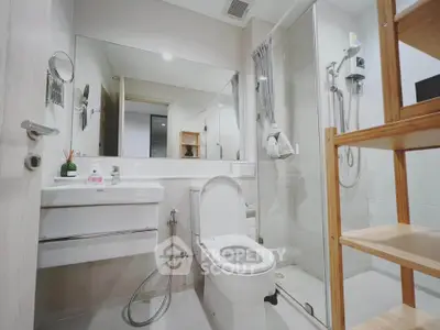 Modern bathroom with sleek fixtures and glass shower enclosure in a contemporary apartment.
