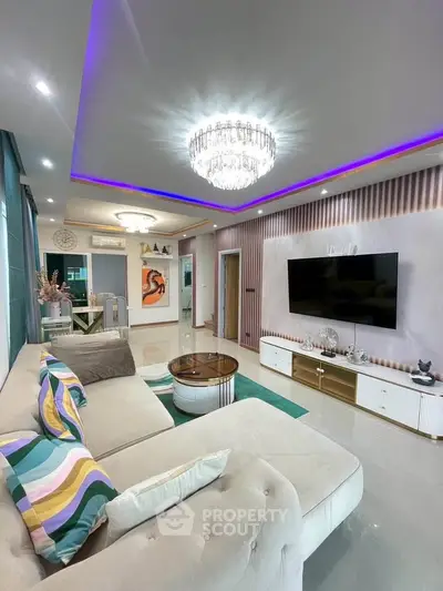 Luxurious living room with modern decor, plush sofa, and elegant chandelier lighting.
