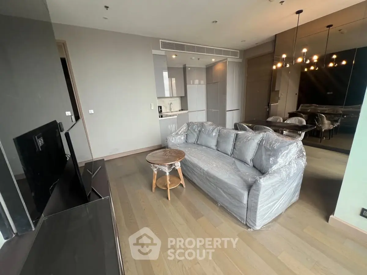 Modern living room with stylish furniture and open kitchen layout in a contemporary apartment.