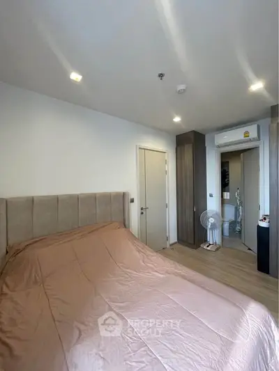 Modern bedroom with stylish decor and wooden flooring in a contemporary apartment.