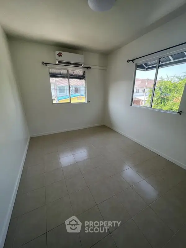 Bright empty room with tiled floor and air conditioning, perfect for customization.