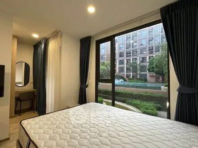 Modern bedroom with large window overlooking pool and garden in luxury apartment