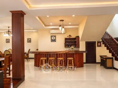 Spacious open-plan living area with elegant wooden bar and dining space