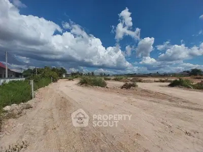 Expansive land plot under a vibrant blue sky, ideal for development opportunities.