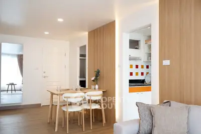 Modern open-plan living room with dining area and stylish kitchen in contemporary apartment.